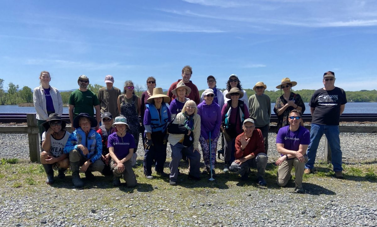 A large group of volunteers pose for a photo before a cleanup event.